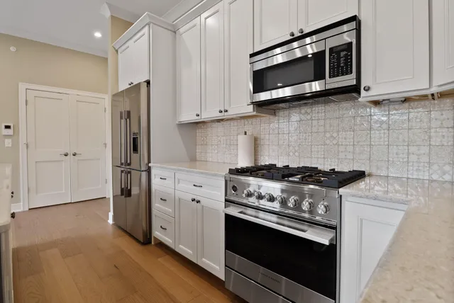 a kitchen with stainless steel appliances wooden cabinets and a stove top oven