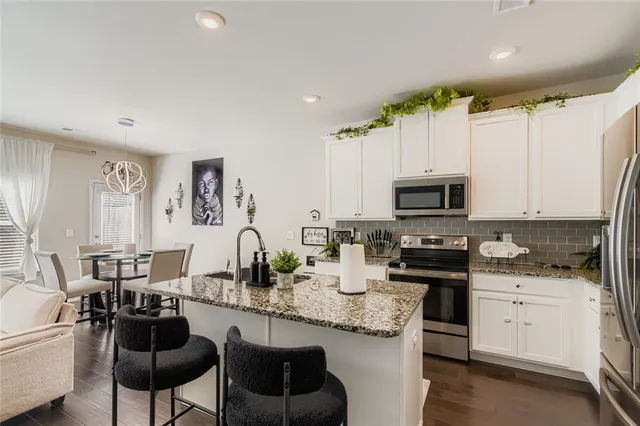 a kitchen with granite countertop a sink stove and cabinets