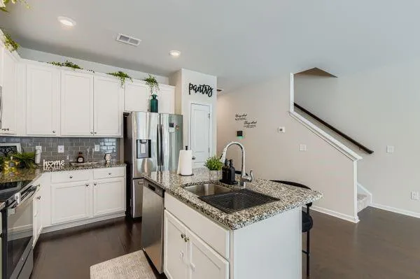 a kitchen with a sink a stove a refrigerator and cabinets