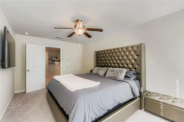 a bedroom with a large bed and a chandelier