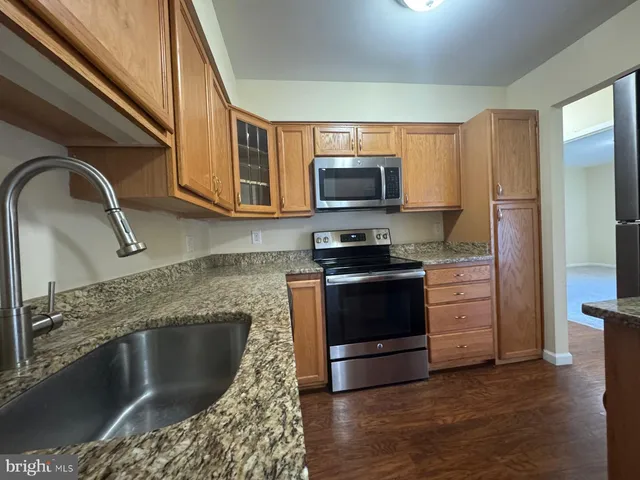 a kitchen with stainless steel appliances granite countertop a stove a microwave and a refrigerator