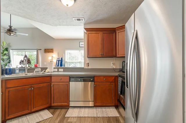 a kitchen with a sink a refrigerator and cabinets