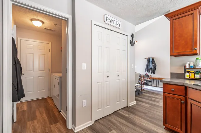 a view of a kitchen from the hallway with wooden floor
