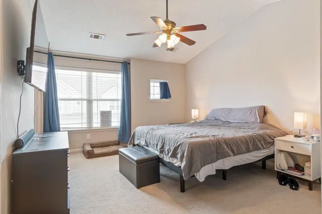 a spacious bedroom with a bed and a chandelier