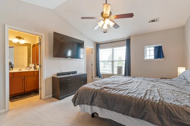 a bedroom with a large bed a flat tv screen and dresser
