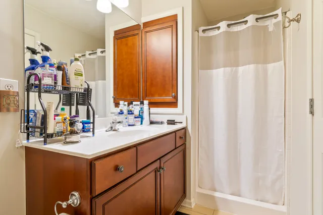 a bathroom with a sink mirror and a shower