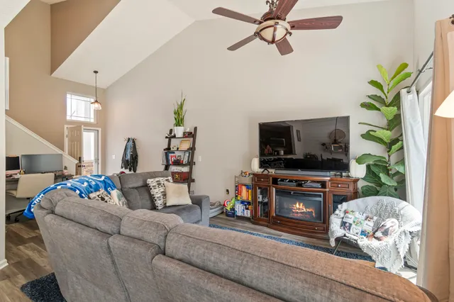 a living room with furniture a flat screen tv and a fireplace