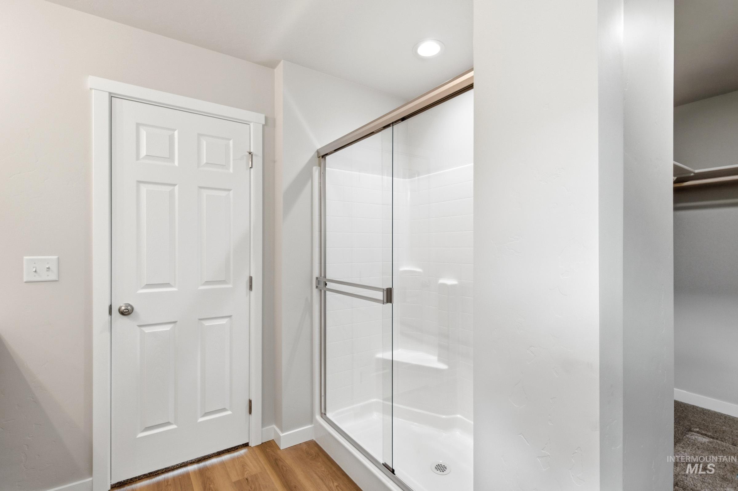 13734 Redway Court Caldwell, ID 83607 - Photo 19 of 20 Full bath featuring a shower stall, a walk in closet, light wood-style flooring, and recessed lighting