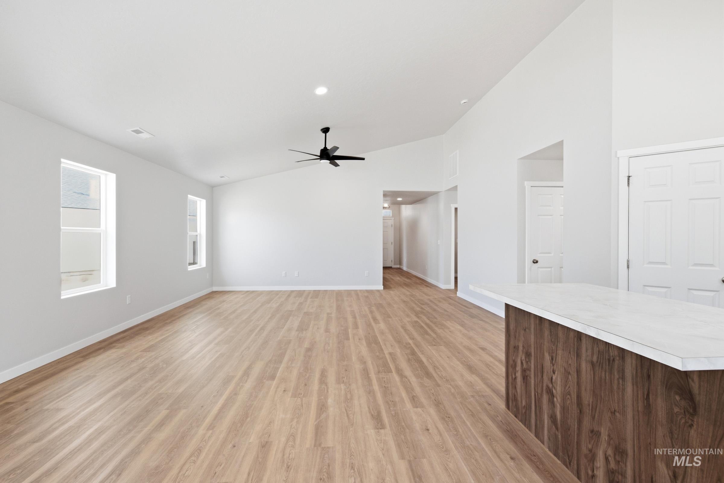 13734 Redway Court Caldwell, ID 83607 - Photo 6 of 20 Unfurnished living room featuring lofted ceiling, light wood-type flooring, and ceiling fan