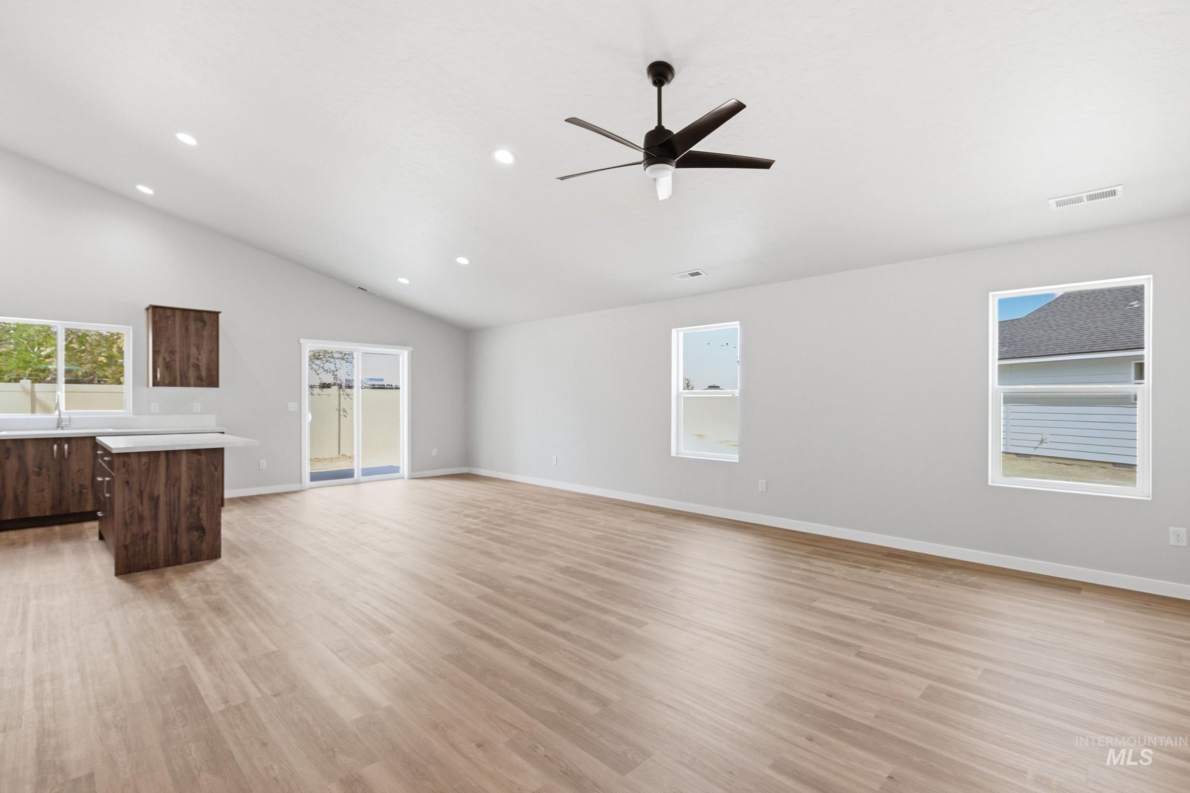 13734 Redway Court Caldwell, ID 83607 - Photo 10 of 20 Unfurnished living room with a ceiling fan, plenty of natural light, light wood finished floors, lofted ceiling, and recessed lighting