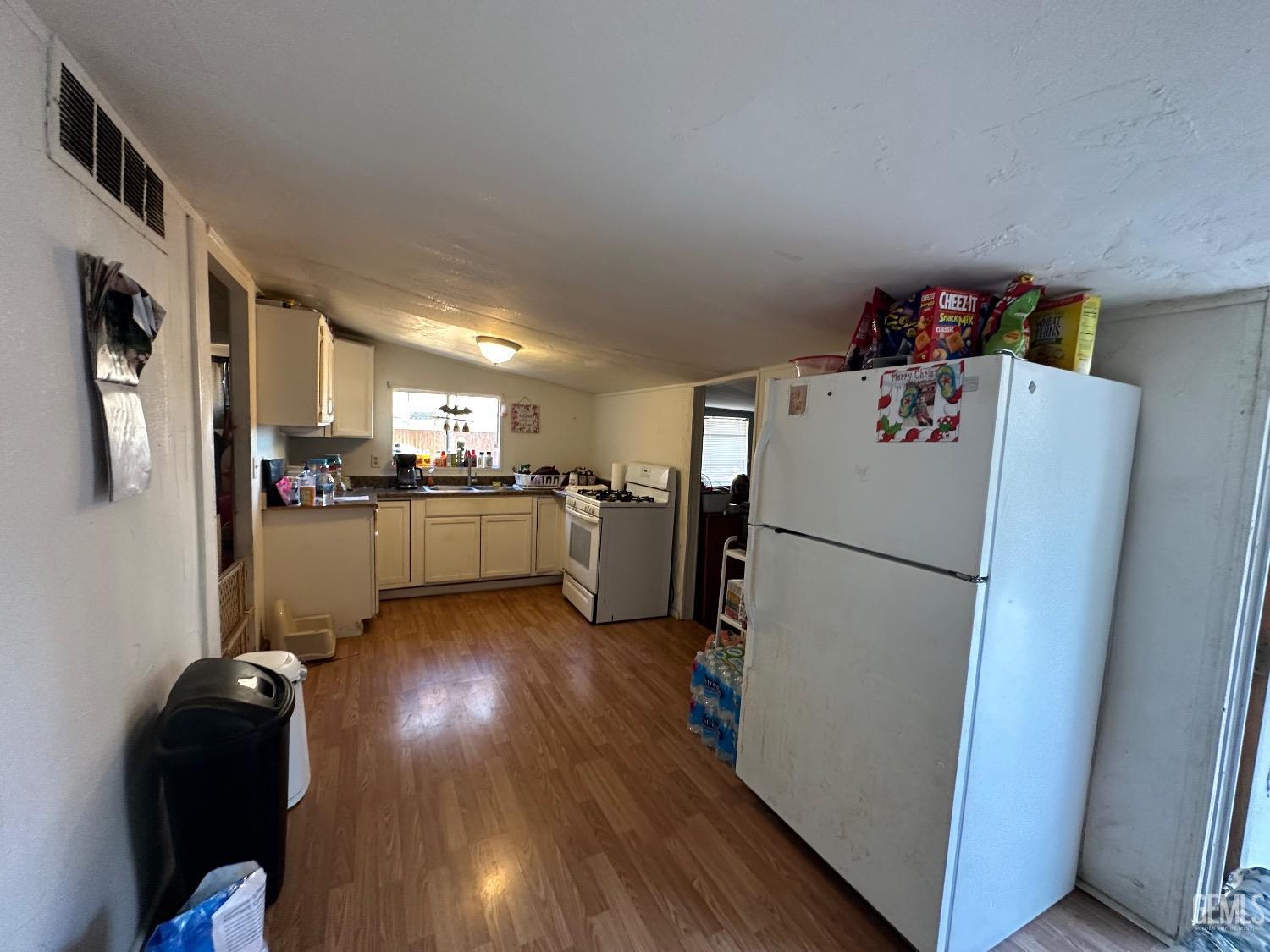 Undisclosed Address Taft, CA 93268 - Photo 6 of 22 a kitchen with refrigerator a microwave and cabinets