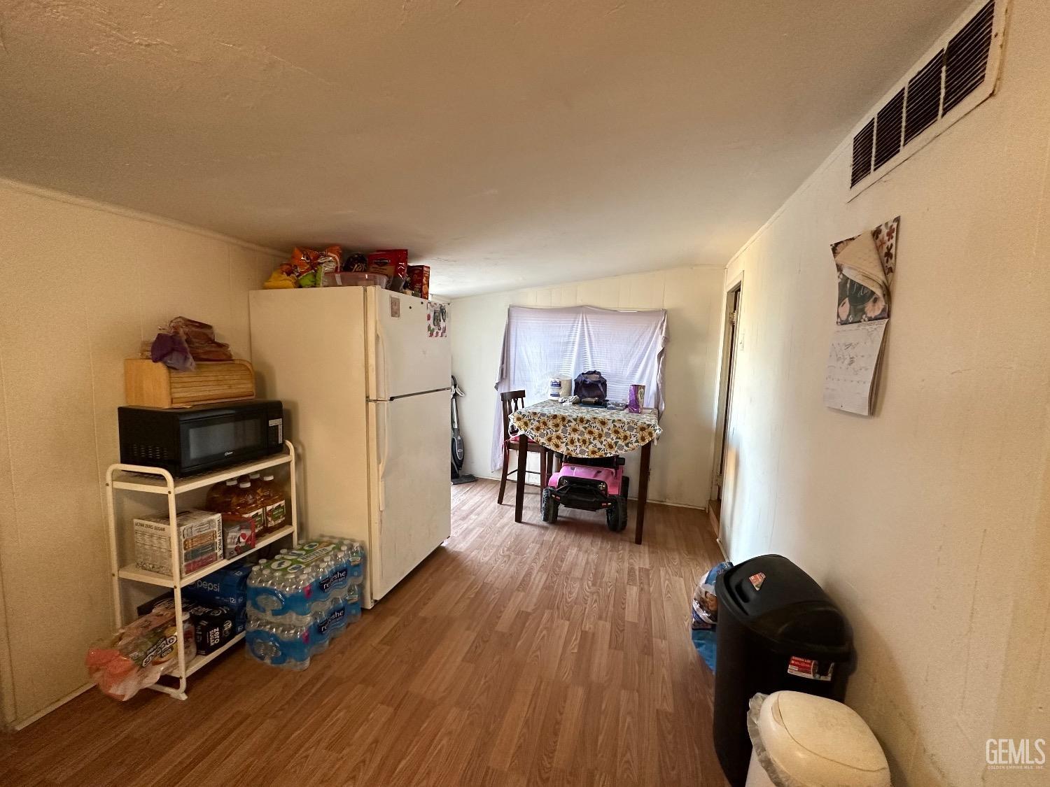 Undisclosed Address Taft, CA 93268 - Photo 8 of 22 a kitchen with a refrigerator and a wooden floor