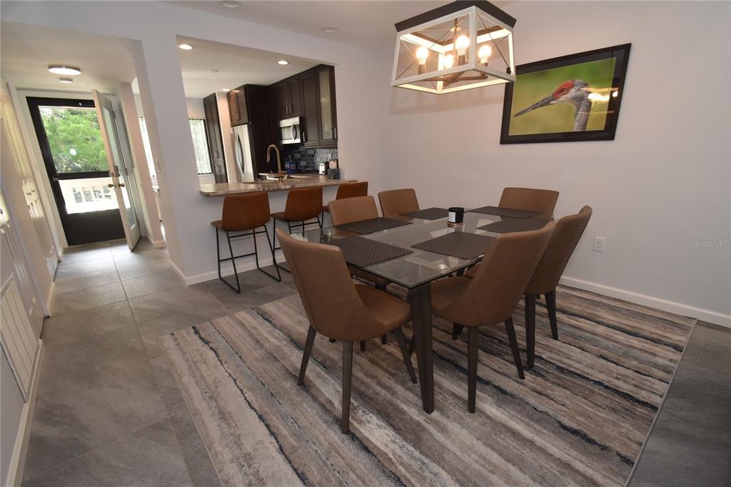 1508 Pelican Cove Road, Unit GR233 Sarasota, FL 34231 - Photo 12 of 37 a view of a dining room with furniture and a potted plant