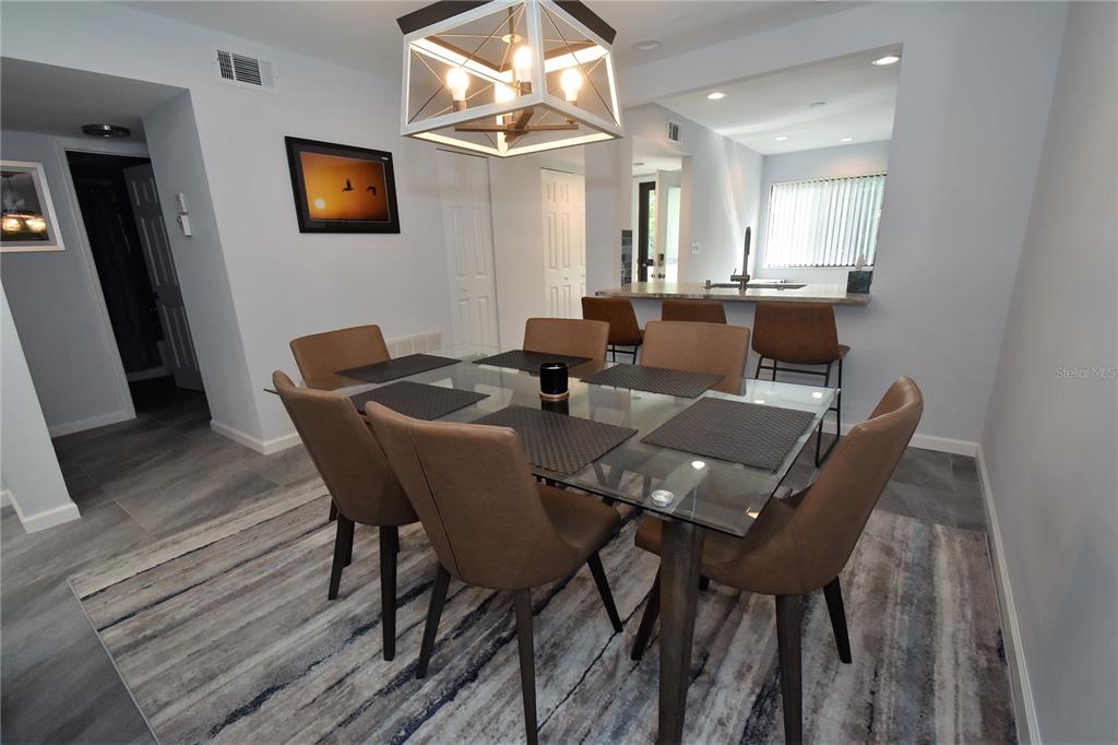 1508 Pelican Cove Road, Unit GR233 Sarasota, FL 34231 - Photo 14 of 37 a view of a dining room with furniture and wooden floor
