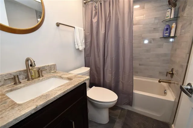 a bathroom with a granite countertop sink toilet and a mirror