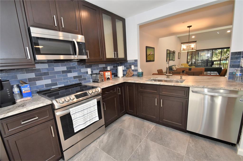 1508 Pelican Cove Road, Unit GR233 Sarasota, FL 34231 - Photo 19 of 37 a kitchen with stainless steel appliances a sink stove and microwave