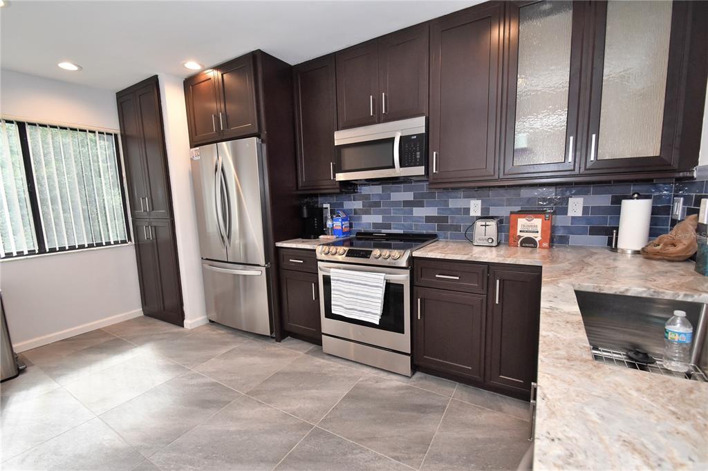 1508 Pelican Cove Road, Unit GR233 Sarasota, FL 34231 - Photo 3 of 37 a kitchen with stainless steel appliances granite countertop a refrigerator stove and microwave