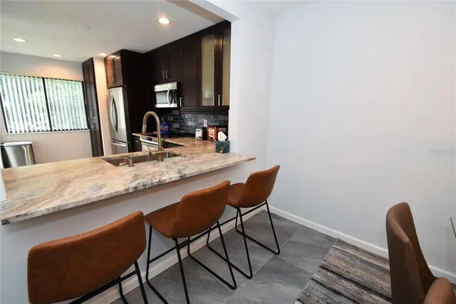 a kitchen with granite countertop sink table and chairs