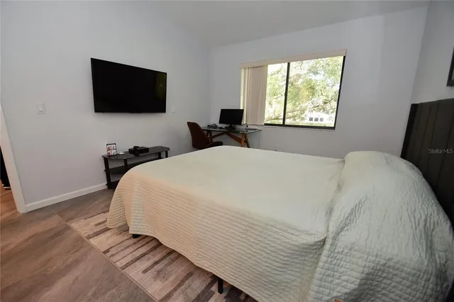 a bedroom with a bed and a flat tv screen on a dresser