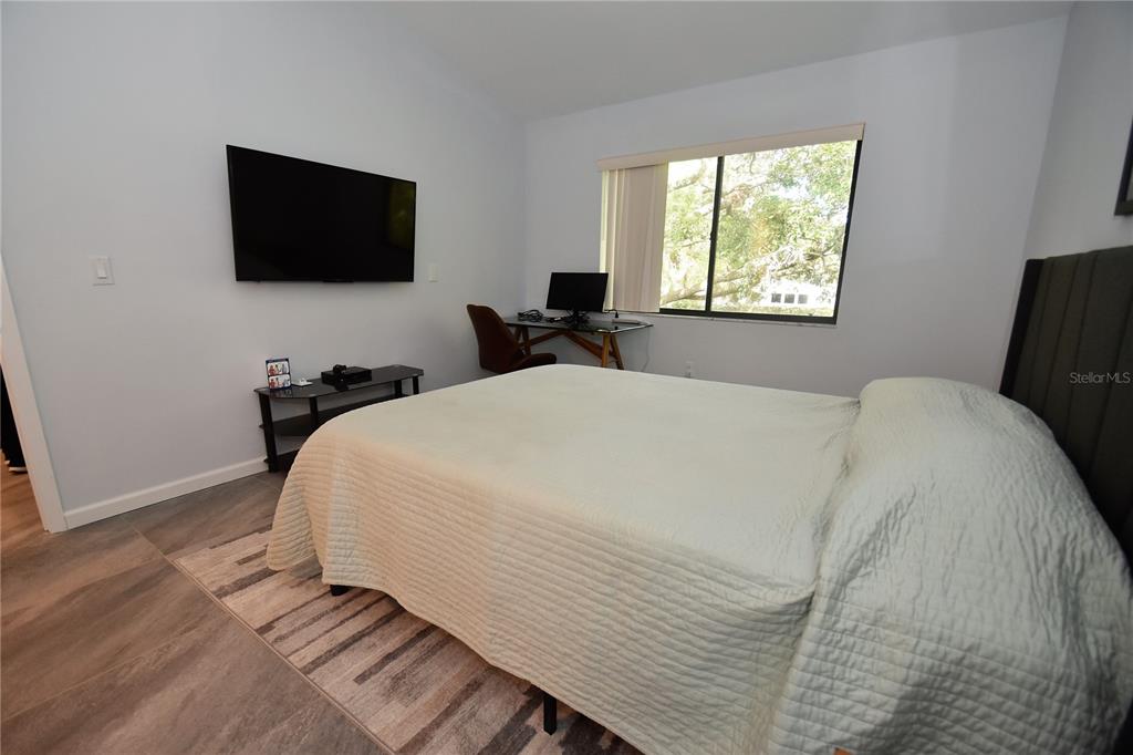 1508 Pelican Cove Road, Unit GR233 Sarasota, FL 34231 - Photo 7 of 37 a bedroom with a bed and a flat tv screen on a dresser