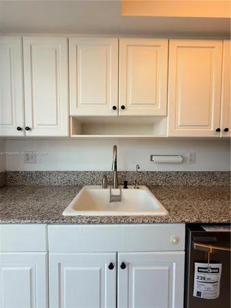a kitchen with granite countertop a sink stove and cabinets