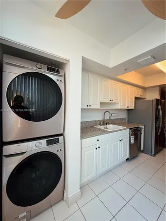 a kitchen with granite countertop a sink a washer and dryer
