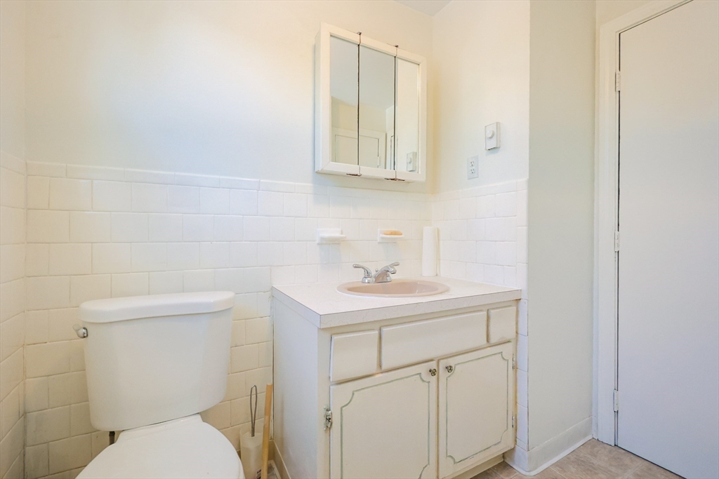 67 Blackstone Street, Unit 67 Bellingham, MA 02019 - Photo 11 of 25 a bathroom with a sink a toilet and a mirror