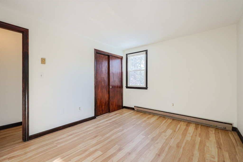 67 Blackstone Street, Unit 67 Bellingham, MA 02019 - Photo 16 of 25 a view of an empty room with wooden floor and a window