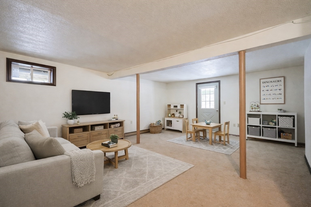 67 Blackstone Street, Unit 67 Bellingham, MA 02019 - Photo 23 of 25 a living room with furniture and a flat screen tv