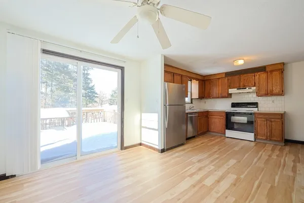 a kitchen with stainless steel appliances wooden floors and white cabinets