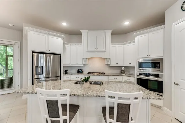 a kitchen with center island table and chairs