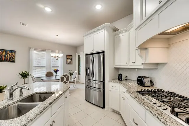 a kitchen with granite countertop a sink appliances and cabinets