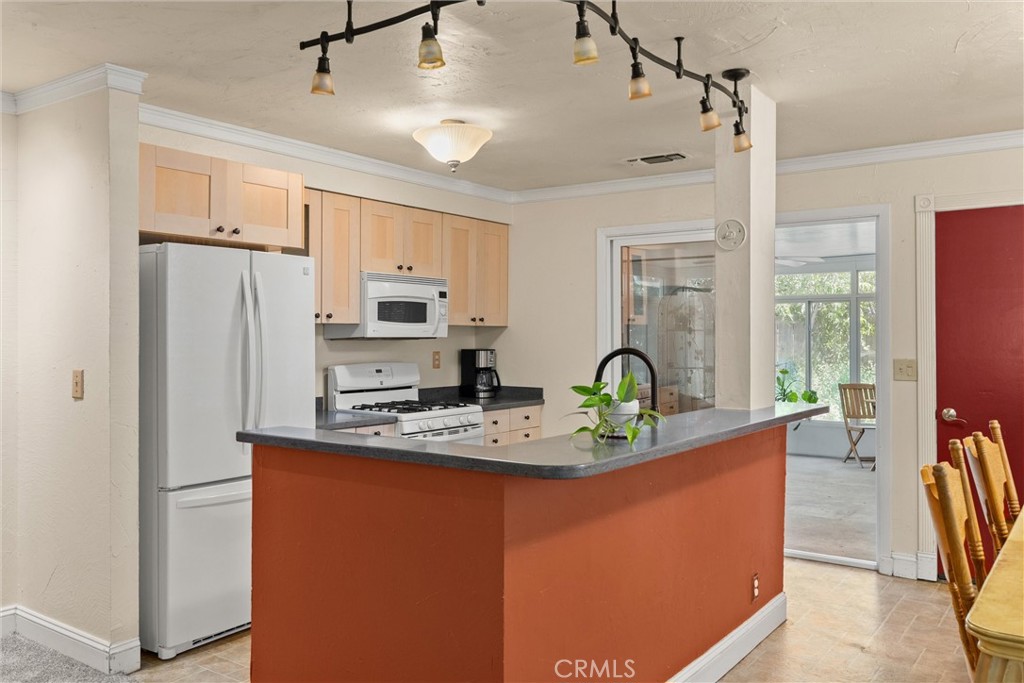3030 Silverbell Road Chico, CA 95973 - Photo 21 of 42 a kitchen with stainless steel appliances granite countertop a refrigerator a sink dishwasher a stove and a dining table with wooden floor