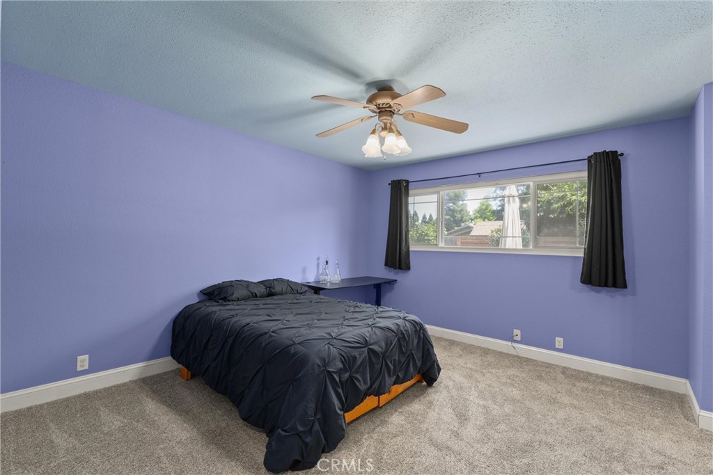 3030 Silverbell Road Chico, CA 95973 - Photo 28 of 42 a bedroom with a bed and a chandelier