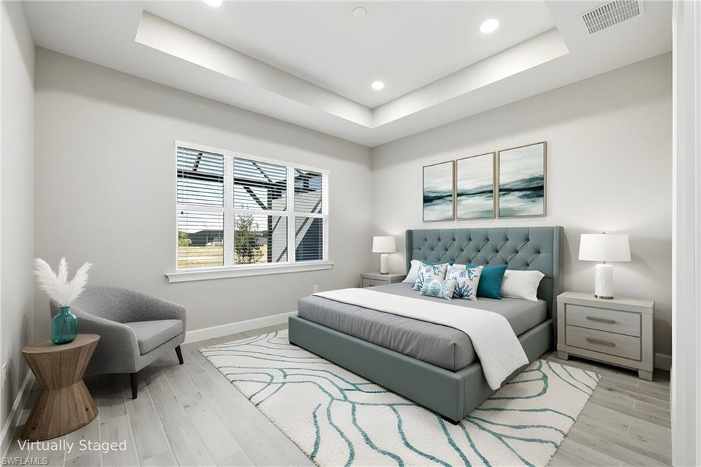 8937 Calypso Court Naples, FL 34113 - Photo 13 of 43 a bedroom with a bed and wooden floor