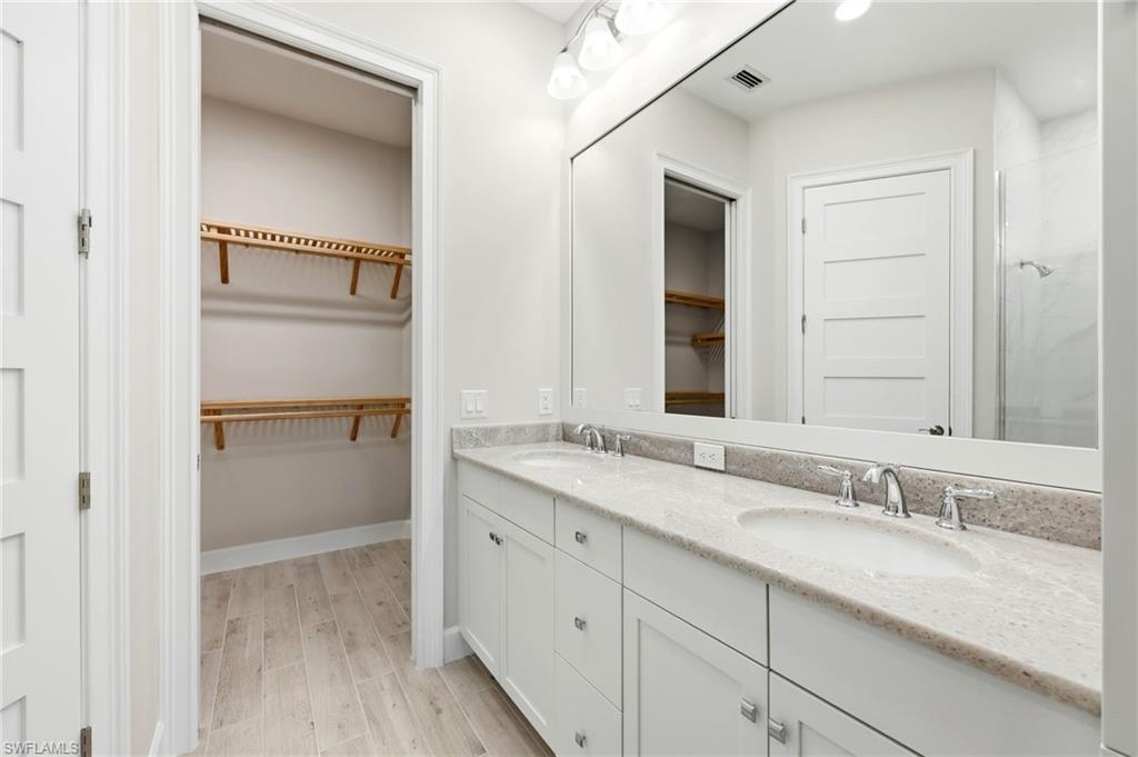 8937 Calypso Court Naples, FL 34113 - Photo 14 of 43 a bathroom with a granite countertop sink and a mirror