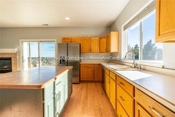 a large kitchen with kitchen island granite countertop a large window and a sink