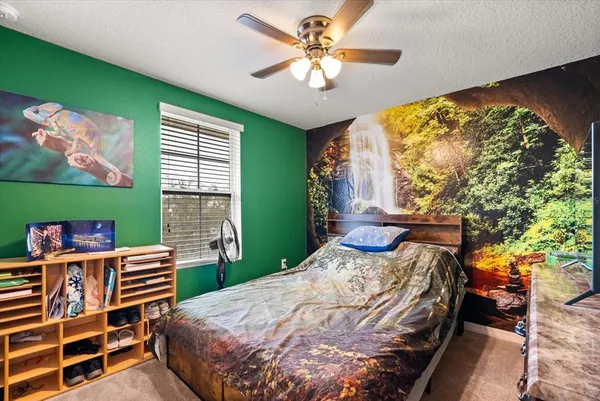 a bedroom with a bed and a bookshelf with wooden floor