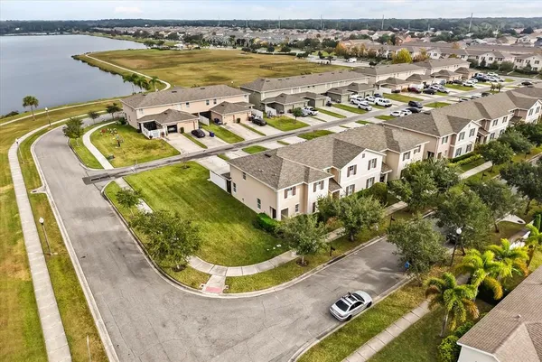 an aerial view of a swimming pool with outdoor seating and yard