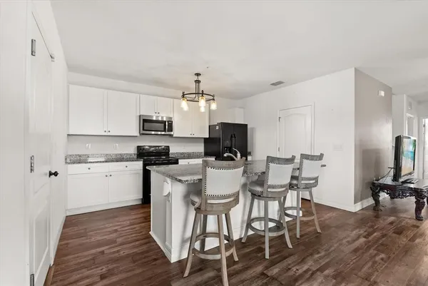a kitchen with a dining table chairs appliances and cabinets