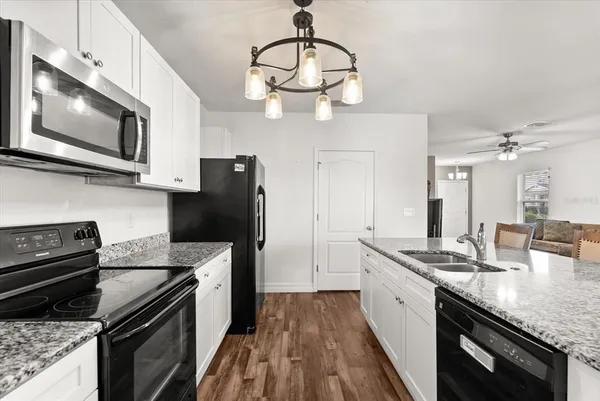 a kitchen with stainless steel appliances granite countertop a refrigerator a stove microwave and cabinets