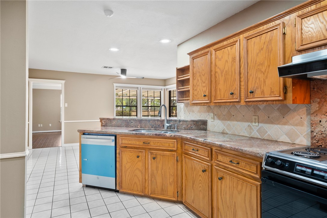 4177 Bobwhite Road Robstown, TX 78380 - Photo 11 of 32 a kitchen with stainless steel appliances granite countertop a stove a sink and a microwave