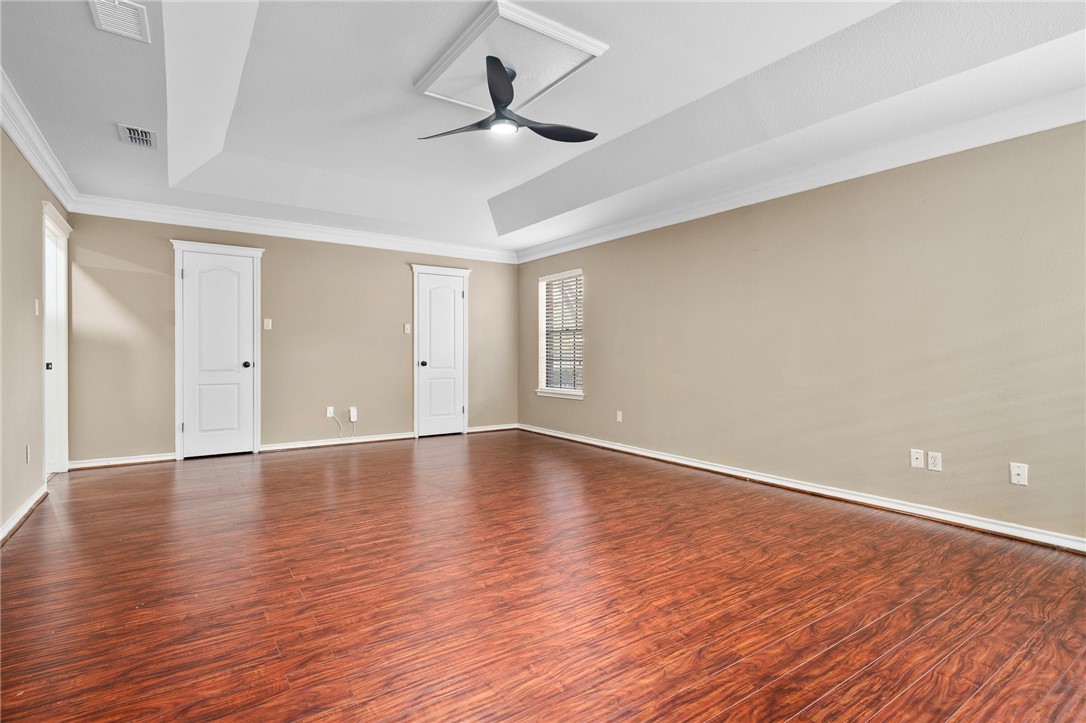 4177 Bobwhite Road Robstown, TX 78380 - Photo 14 of 32 a view of an empty room with wooden floor and a ceiling fan