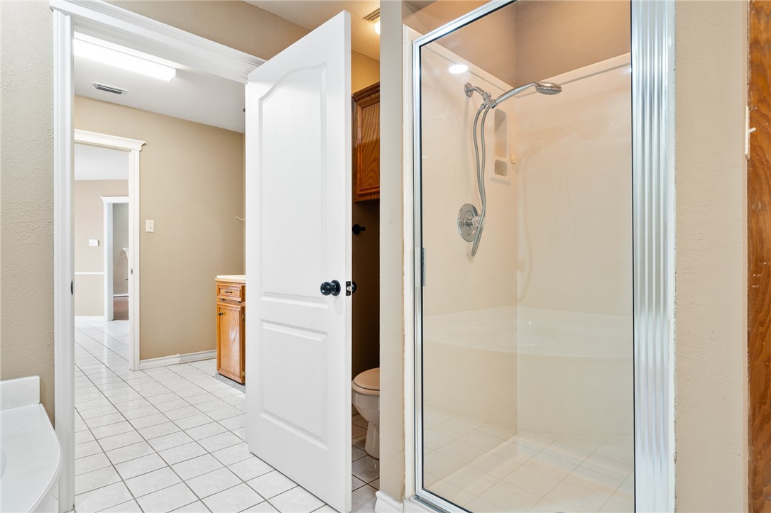 4177 Bobwhite Road Robstown, TX 78380 - Photo 18 of 32 a bathroom with a shower and a glass door