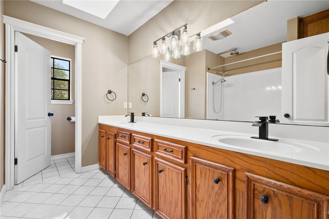 4177 Bobwhite Road Robstown, TX 78380 - Photo 21 of 32 a spacious bathroom with sinks vanity shower and a mirror