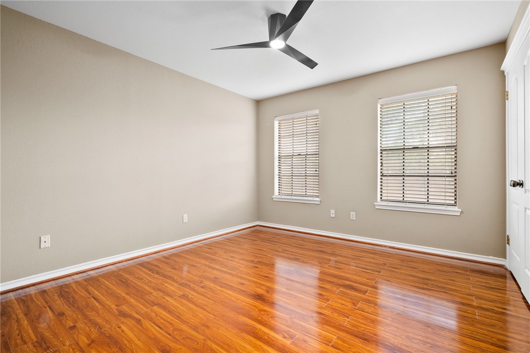 4177 Bobwhite Road Robstown, TX 78380 - Photo 23 of 32 an empty room with wooden floor chandelier fan and windows