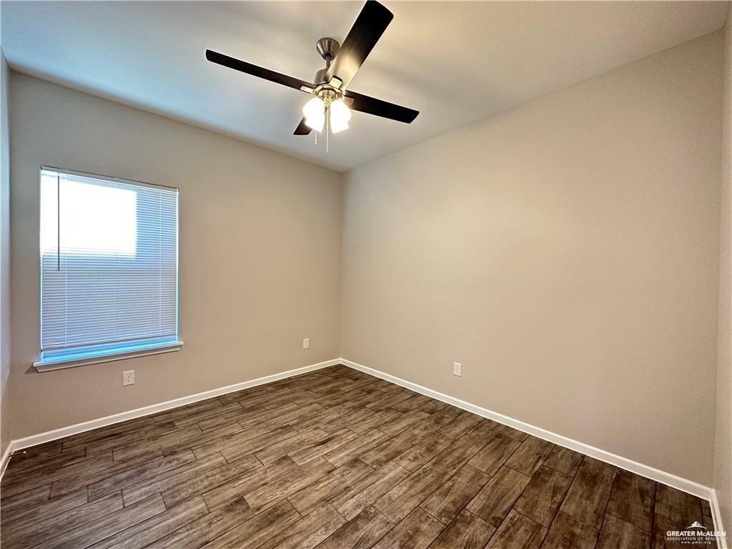 902 Starr Street Mercedes, TX 78570 - Photo 13 of 14 en empty room with wooden floor and windows