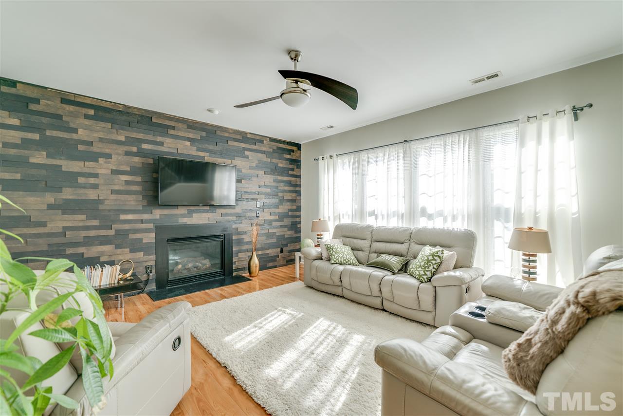 5319 Griffith Park Road Raleigh, NC 27613 - Photo 11 of 25 a living room with furniture a fireplace and a flat screen tv