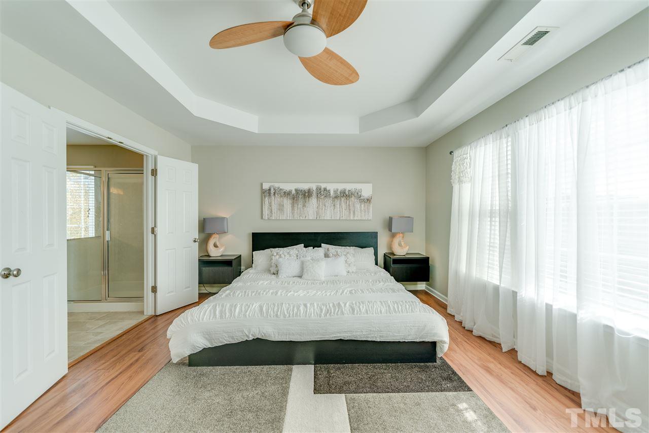 5319 Griffith Park Road Raleigh, NC 27613 - Photo 18 of 25 a bedroom with a large bed and a chandelier
