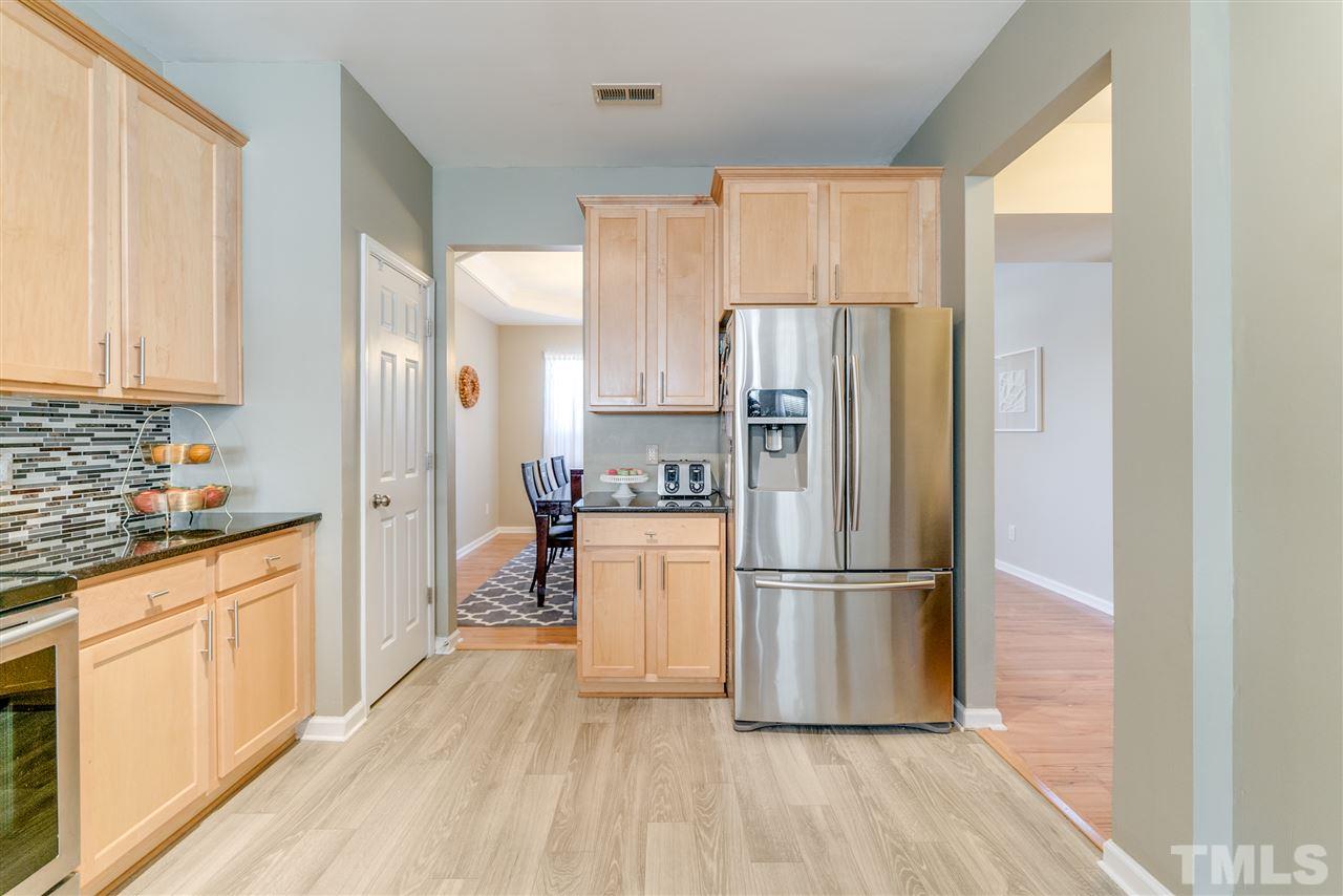 5319 Griffith Park Road Raleigh, NC 27613 - Photo 8 of 25 a kitchen with a refrigerator a sink and dishwasher with wooden floor